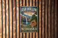 A vintage-style metal sign for Ash Hollow State Historical Park in Nebraska, featuring a waterfall and a Native American symbol.