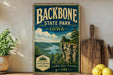 A vintage-style sign for Backbone State Park in Iowa, featuring a scenic landscape with a river, mountains, and pine trees.