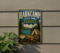 A vintage-style metal sign for Barkcamp State Park in Ohio, featuring a scenic landscape with pine trees, a lake, and a tent, mounted on a wall.