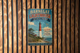 A vintage-style metal sign for Barnegat Lighthouse State Park in New Jersey, featuring a lighthouse and a coastal landscape.