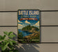 A vintage-style metal sign for Battle Island State Park in New York, featuring a scenic landscape with a lake, mountains, and a castle.