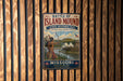 A vintage metal sign with the title "Battle of Island Mound State Historic Site" is displayed on a wooden wall.