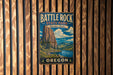 A vintage metal sign for Battle Rock State Park in Oregon, featuring a scenic landscape with a mountain, river, and forest.