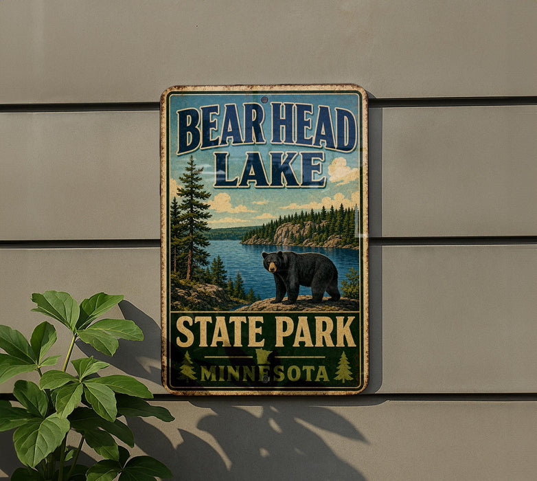 A metal sign with the text "BEAR HEAD LAKE STATE PARK MINNESOTA" and an illustration of a bear in a forest setting.