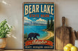 A vintage-style metal sign for Bear Lake State Park in Idaho, featuring a bear walking along a beach and mountains in the background.