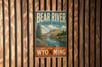 A vintage-style metal sign for Bear River State Park, featuring a scenic landscape with a river, mountains, and pine trees.