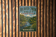 A vintage metal sign for Beaver Creek Valley State Park in Minnesota, featuring a scenic landscape with a river and forest.
