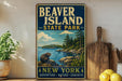 A vintage-style sign for Beaver Island State Park in New York, featuring a scenic illustration of a beaver on a rock overlooking a lake surrounded by pine trees.