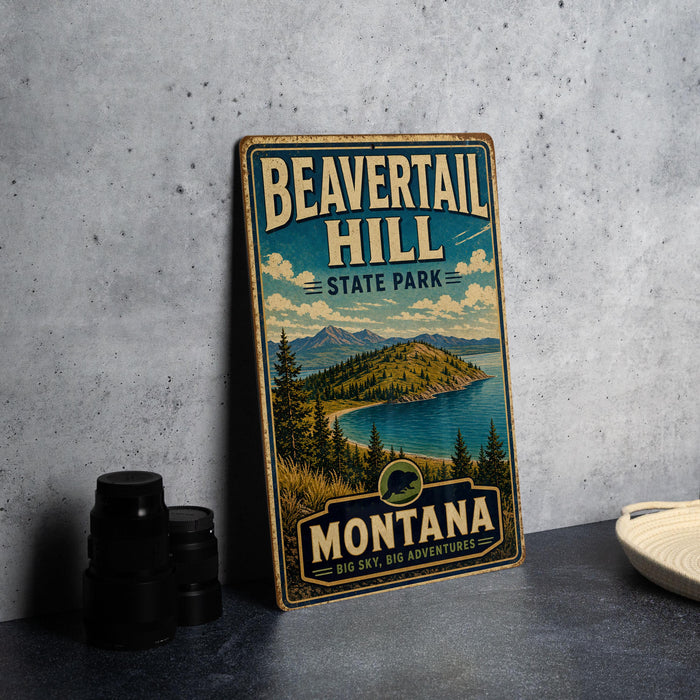 A vintage-style metal sign for Beavertail Hill State Park in Montana, featuring a scenic landscape with mountains, pine trees, and a lake.