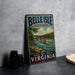 A vintage-style metal sign for Belle Isle State Park in Virginia, featuring a scenic illustration of a river, bridge, and wildlife.