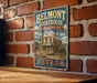 A vintage-style metal sign for Belmont Courthouse, a historic site in Nevada, is displayed on a brick wall.