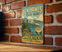 A vintage-style metal sign for Ben Hawes State Park in Kentucky, featuring a scenic landscape with a lake and mountains.
