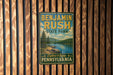 A vintage-style metal sign for Benjamin Rush State Park in Pennsylvania, featuring a scenic landscape with a lake and mountains.