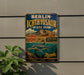 A vintage-style metal sign for Berlin-Ichthyosaur State Park, featuring a large illustration of a sea dinosaur and the text "Berlin-Ichthyosaur State Park" along with the words "EXPLORE NEVADA STATE PARK" and "Discovery, Learn, Protect".