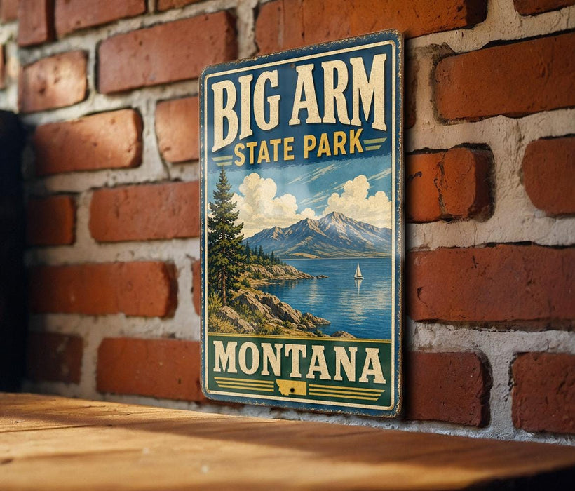 A vintage-style metal sign for Big Arm State Park in Montana, featuring a scenic landscape with mountains, a lake, and a sailboat.
