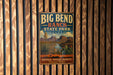 A vintage-style metal sign for Big Bend Ranch State Park in Texas, featuring a desert landscape with mountains, cacti, and a river.
