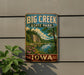 A vintage-style metal sign for Big Creek State Park in Iowa, featuring a scenic landscape with a lake, mountains, and colorful flowers.