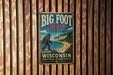 A vintage-style metal sign for Big Foot Beach State Park in Wisconsin, featuring a large Sasquatch silhouette and a scenic beach landscape.