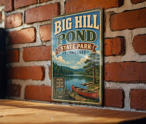 A vintage-style metal sign for Big Hill Pond State Park in Tennessee, featuring a scenic illustration of a lake, forest, and canoe.