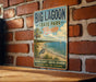 A vintage-style metal sign for Big Lagoon State Park in Florida, featuring a beach scene with a crane and palm trees.