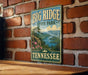 A vintage-style metal sign for Big Ridge State Park in Tennessee, featuring a scenic landscape with mountains, forests, and a lake.