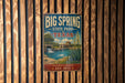 A vintage-style sign for Big Spring State Park in Texas, featuring a scenic illustration of a lake, waterfall, and surrounding landscape.