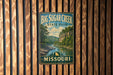 A vintage metal sign for Big Sugar Creek State Park in Missouri, featuring a scenic landscape with a river and mountains.