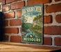 A vintage-style metal sign for Big Sugar Creek State Park in Missouri, featuring a scenic landscape with a river and mountains.