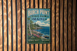 A vintage metal sign for Birch Point State Park in Maine, featuring a scenic landscape with a rocky coastline, pine trees, and a blue sky with clouds.