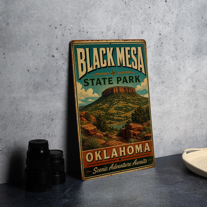 A vintage-style sign for Black Mesa State Park in Oklahoma, featuring a scenic landscape with mountains and a river.