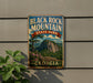 A vintage metal sign for Black Rock Mountain State Park in Georgia, featuring a scenic mountain landscape with a pine tree and flowers.