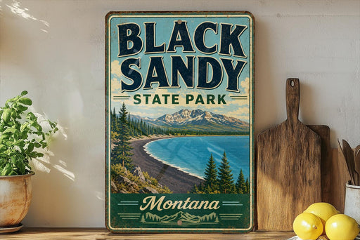 A vintage-style sign for Black Sandy State Park in Montana, featuring a scenic landscape with mountains, pine trees, and a lake.