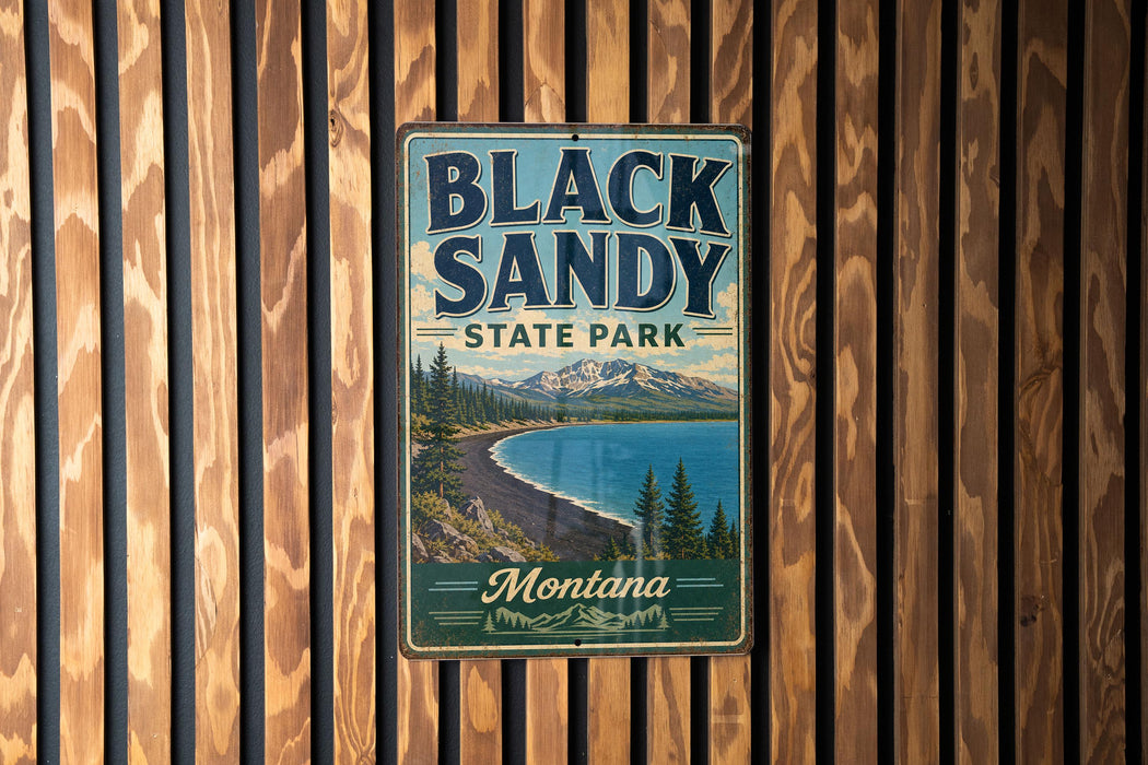 A vintage metal sign for Black Sandy State Park in Montana, featuring a scenic landscape with a lake, mountains, and pine trees.