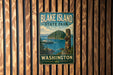 A vintage-style sign for Blake Island State Park in Washington, featuring a scenic image of the park and a boat on the water.