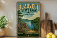A vintage-style sign for Blauvelt State Park in New York, featuring a scenic image of the Hudson Valley with a lake and forest.