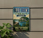 A vintage-style sign for Blue Rock State Park in Ohio, featuring a scenic landscape with a lake and mountains.