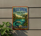 A vintage-style metal sign for Bluespring State Park in Florida, featuring a manatee and a tropical landscape.