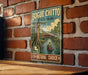 A vintage-style metal sign for Bogue Chitto State Park in Louisiana, featuring a scenic illustration of a person in a canoe on a river surrounded by lush greenery.