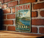 A vintage-style metal sign for Bonham State Park in Texas, featuring a scenic landscape with a lake and trees.
