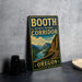 A vintage-style metal sign for the Booth State Scenic Corridor in Oregon, featuring a scenic mountain landscape and a winding road.