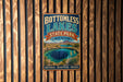 A vintage-style metal sign for Bottomless Lakes State Park in New Mexico, featuring a scenic image of the lake surrounded by mountains and desert landscapes.