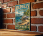 A vintage-style metal sign for Boulder Beach State Park in Vermont, featuring a scenic landscape with mountains, trees, and a lake.