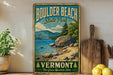 A vintage-style sign for Boulder Beach State Park in Vermont, featuring a scenic landscape with mountains, trees, and a lake.