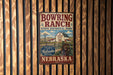 A vintage-style metal sign for Bowring Ranch State Historical Park in Nebraska, featuring a barn and windmill in the background.