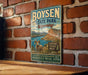 A vintage-style metal sign for Boysen State Park in Wyoming, featuring a scenic illustration of a mountain landscape with a wind-swept river and a ram.