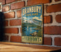 A vintage metal sign for Brandbury State Park in Vermont, featuring a scenic landscape with a mountain, lake, and sailboat.