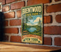 A vintage-style metal sign for Brentwood State Park, featuring a scenic landscape with a lake and trees, mounted on a brick wall.