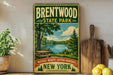 A vintage-style sign for Brentwood State Park, featuring a scenic landscape with a lake and trees, is displayed on a wooden shelf next to a wooden cutting board and some lemons.