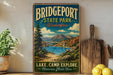 A vintage-style metal sign for Bridgeport State Park in Washington, featuring a scenic landscape with a lake, mountains, and a bridge.