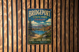 A vintage metal sign for Bridgeport State Park in Washington, featuring a scenic landscape with a lake, bridge, and mountains.